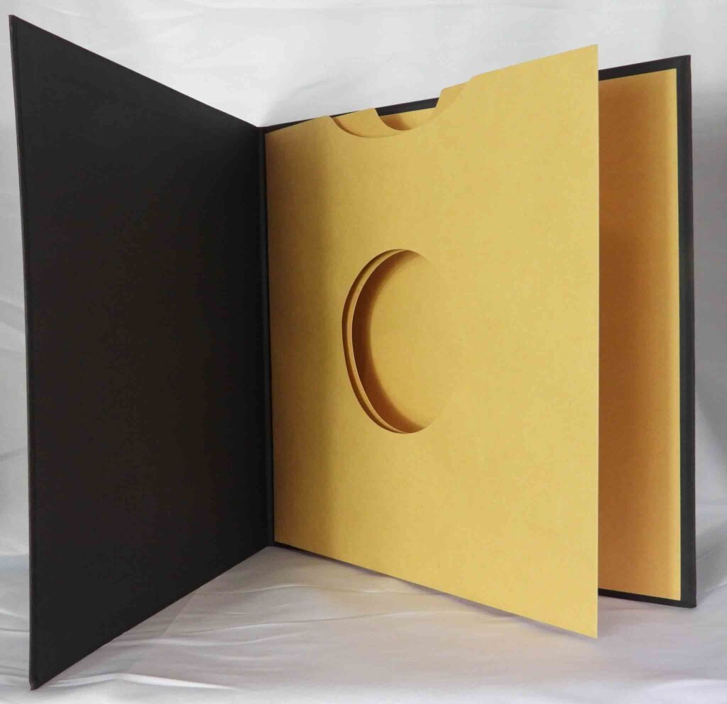 Vinyl hardcover book with swinging sleeve die cut fiberboard exterior fabric paper linen wrap white foil